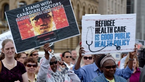 Health care providers and supporters hold a rally to protest federal cuts to refugee care on Parliament Hill in Ottawa, Monday, June 16, 2014. (Sean Kilpatrick / THE CANADIAN PRESS)