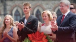 Prime Minister Stephen Harper is pictured with his wife Laureen Harper and their children Ben and Rachel during Canada Day celebrations on the cover of the prime minister's 2014 Christmas card. (THE CANADIAN PRESS)