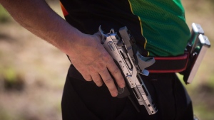 A man is shown holding a handgun in this July 2014 file photo. (Darryl Dyck / THE CANADIAN PRESS)