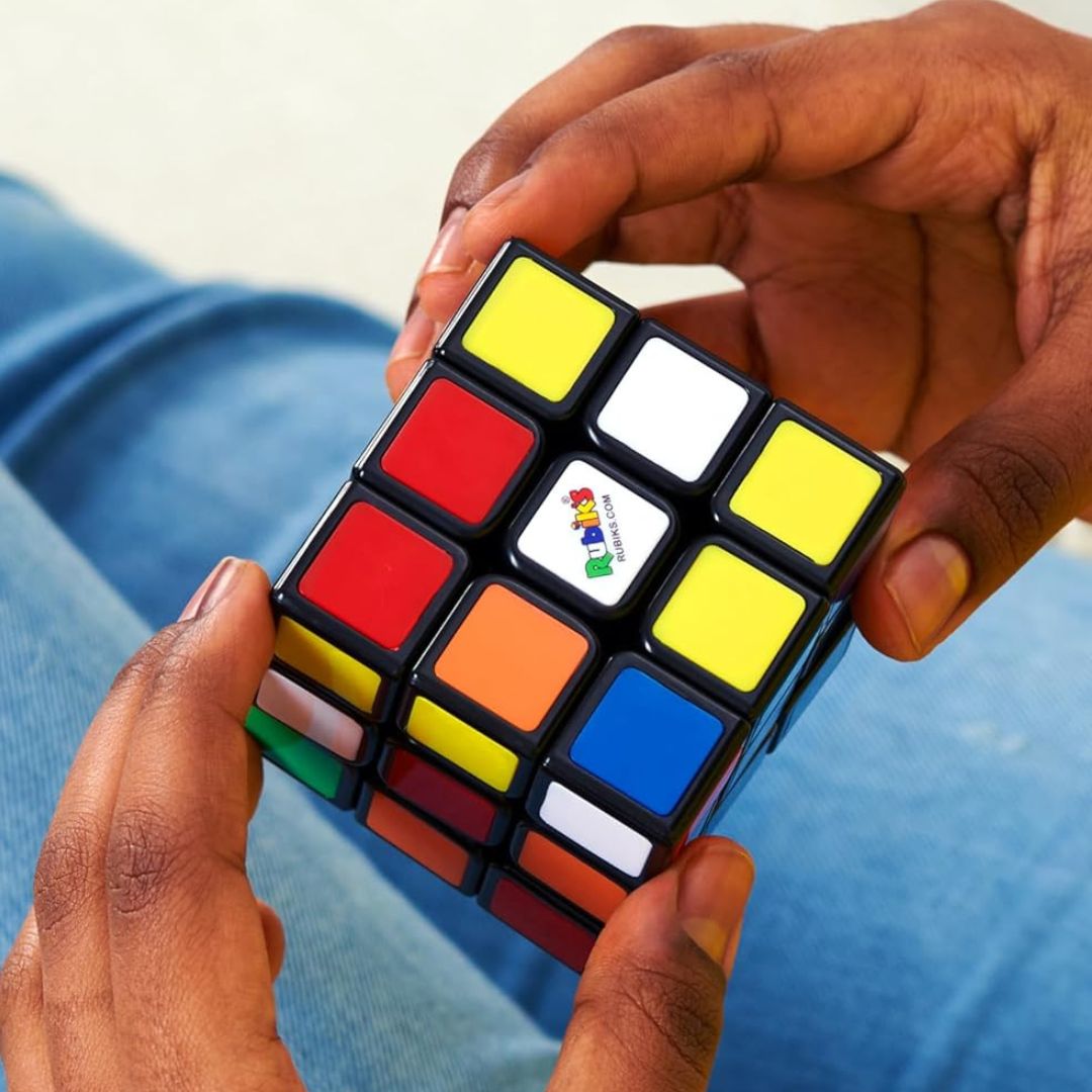 A kid twisting a Rubik’s Cube.