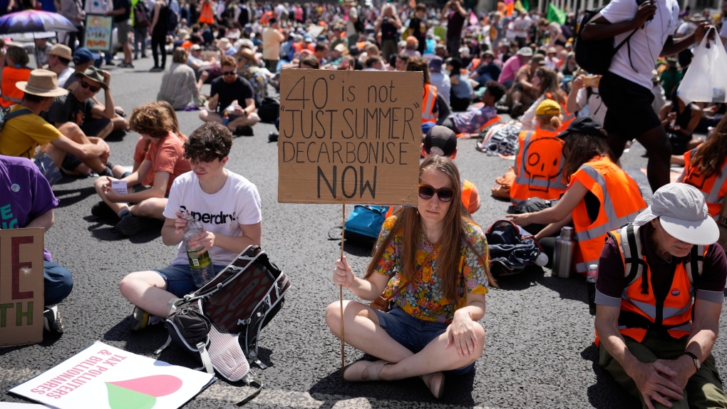 Members of environmental groups including Just Stop Oil, the Peace and Justice Project and Insulate Britain take part in a mass protest, in Parliament Square in London, Saturday, July 23, 2022. (AP Photo/Alessandra Tarantino)