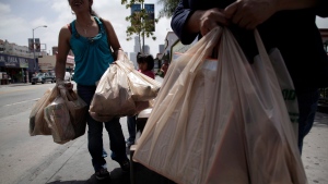 Two women wait for a bus after their grocery shopping in Los Angeles, Thursday, May 24, 2012. (AP / Jae C. Hong)