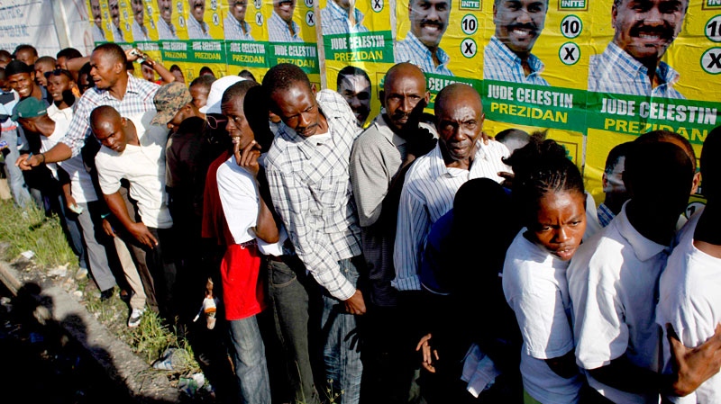 Voters wait in line to cast their ballots next to a wall covered with posters of presidential candidate Jude Celestin, of the INITE party, during general elections in Port-au-Prince, Haiti, Sunday, Nov. 28, 2010. (AP / Ramon Espinosa)