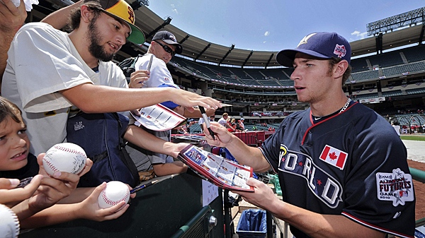 Brett Lawrie of Canada, playing for the World Team, signs autographs prior to the 2010 All-Star Futures game against the U.S. team on Sunday, July 11, 2010, in Anaheim, Calif. (AP Photo/Mark J. Terrill)