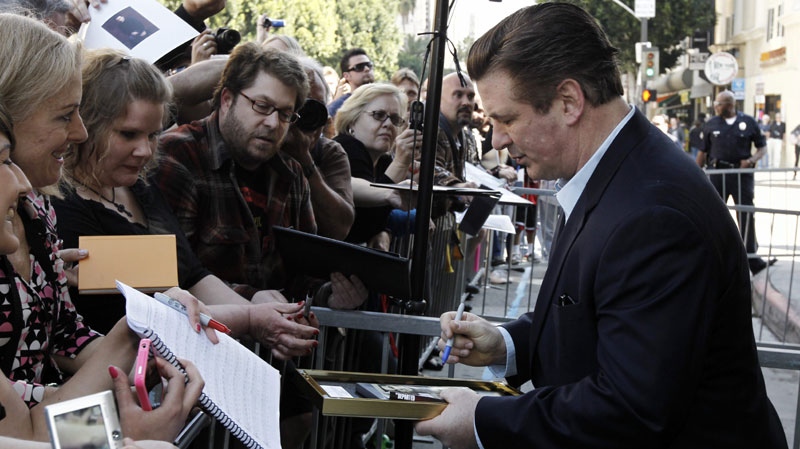 Alec Baldwin signs autographs for fans after he received a star on the Hollywood Walk of Fame in Los Angeles on Monday, Feb. 14, 2011. (AP Photo/Matt Sayles)