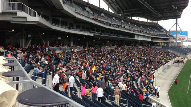 The crowd begins to fill Investors Group Field for the One Heart Winnipeg mulch-denominational church service on Sunday.