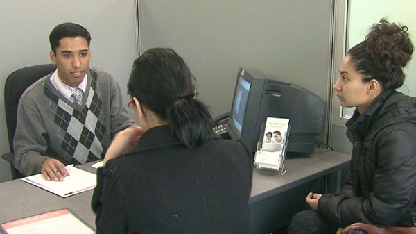 A woman is seen filing her taxes with an employee from H&R Block.