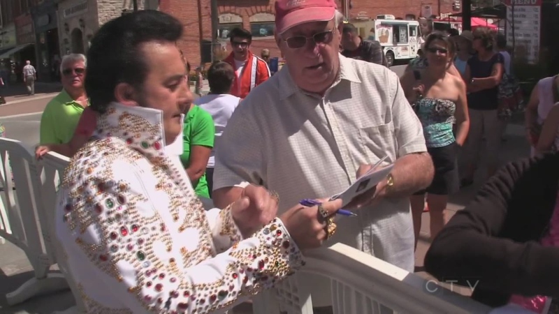 An Elvis Presley impersonator signs an autograph at the 2013 edition of the Collingwood Elvis Festival.