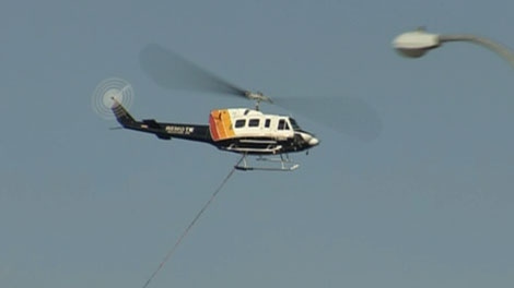 A helicopter loaded down with water helps fight wildfires in northern Alberta. May 18, 2011. (CTV)