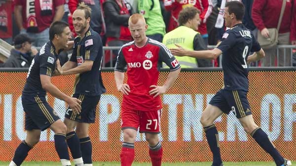 Toronto FC 's Richard Eckersley (centre right) hangs his head as Philadelphia Union's Kyle Nakawaza (left) celebrates scoring his team's third goal with Justin Mapp (centre left) and Sebastien LeToux during first half MLS action in Toronto on Saturday May 28, 2011.(Chris Young / THE CANADIAN PRESS)