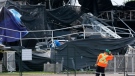 Workers install a security fence in front of the Ottawa Bluesfest main stage which collapsed during a storm in Ottawa, Monday July 18, 2011. (Adrian Wyld / THE CANADIAN PRESS)  