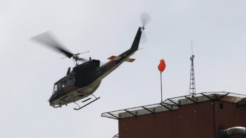 A Thai military helicopter leaves a rooftop carrying unidentified leaders Saturday, April 11, 2009, in Pattaya, Thailand.