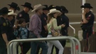 One of the two protesters is escorted from the Calgary Stampede racetrack on Friday evening