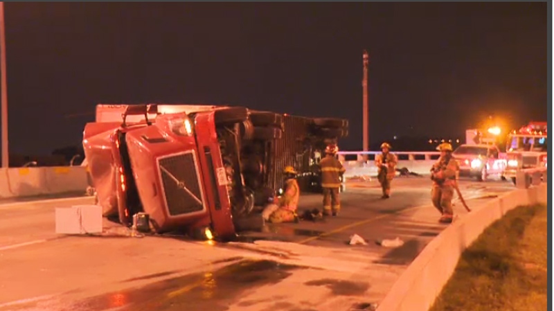 The tractor trailer is seen stuck on its side foll