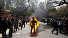 A Tibetan man screams as he runs engulfed in flames after self-immolating at a protest ahead of Chinese President Hu Jintao's visit to India, in New Delhi India, Monday, March 26, 2012. (AP / Manish Swarup)