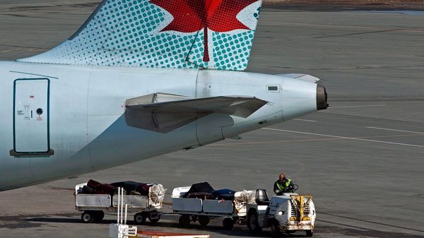 An Air Canada employee is shown moving baggage on the tarmac at Halifax Stanfield International Airport in Enfield, N.S. on March 8, 2012. (Andrew Vaughan / THE CANADIAN PRESS)