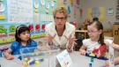 Premier Kathleen Wynne sits with school children in Markham, Ont., on Wednesday, May 28, 2014 (Frank Gunn / The Canadian Press)