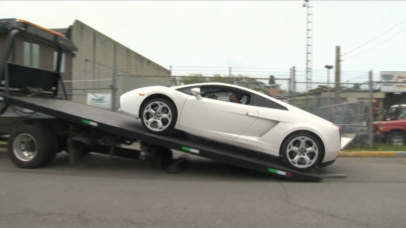 A white Lamborghini impounded for doing twice the posted speed limit on the Trans-Canada Highway in Victoria, B.C. is loaded onto a flatbed truck. Saturday, May 16, 2015. (CTV)