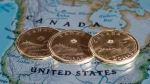 Canadian dollar coins, or Loonies, are displayed on a map of North America in Montreal on January 9, 2014.  THE CANADIAN PRESS/Paul Chiasson