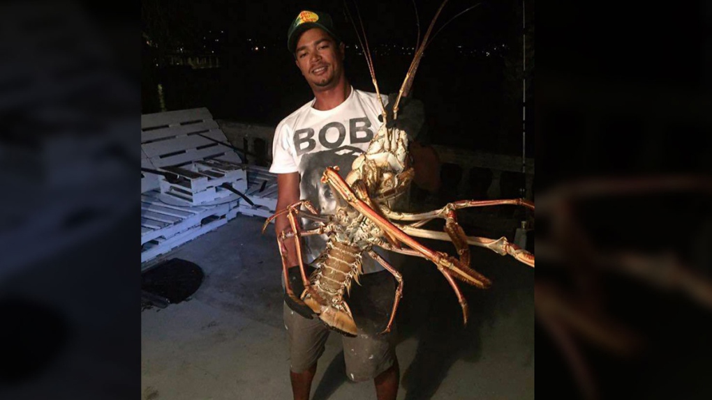 Tristan Loescher holds up a 14-pound spiny lobster