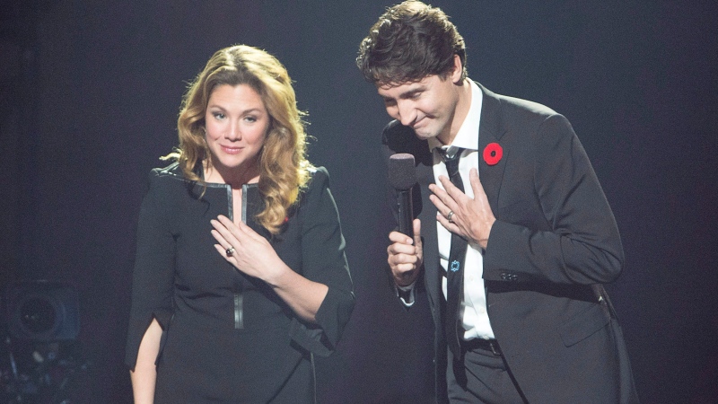 Prime Minister Justin Trudeau and his wife, Sophie Gregoire Trudeau, take a bow after speaking to the audience under a portrait of Leonard Cohen during a tribute to the late singer Monday, November 6, 2017 in Montreal. (THE CANADIAN PRESS/Ryan Remiorz)