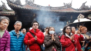 People pray for good luck during the Lunar NewYear at the Lonshan Temple in Taipei, Taiwan, Saturday, Feb. 17, 2018. (AP Photo/Chiang ying-ying)