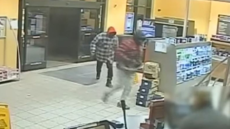 This image taken from YouTube video shows two suspects sought in a robbery in Windsor, Ont. on Tuesday, Nov. 27, 2018. (Windsor Police / YouTube)
