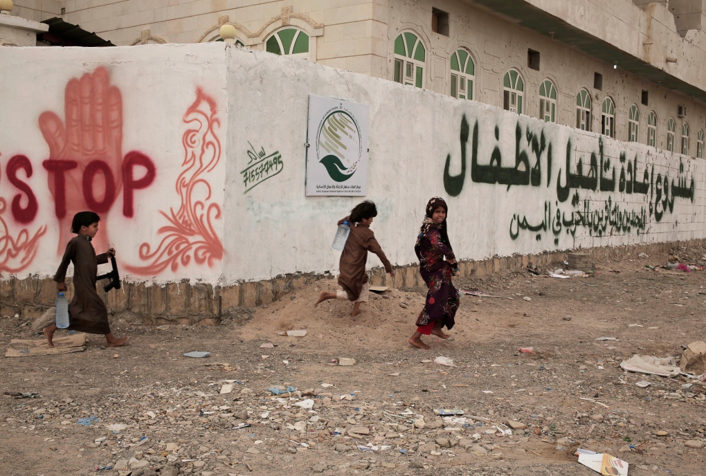 Children run in the yard of a building in Yemen