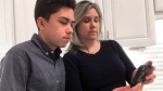 In this Jan. 31, 2019, file photo Grant Thompson and his mother, Michele, look at an iPhone in the family's kitchen in Tucson, Ariz., on Thursday, Jan. 31, 2019. Apple has released an iPhone update to fix a FaceTime flaw that allowed people to eavesdrop on others while using its group video chat feature. The repair is included in the latest version of Apple's iOS 12 system, which became available to install Thursday. Apple credited the Tucson teenager, Grant Thompson, for discovering the FaceTime bug. (AP Photo/Brian Skoloff, File)
