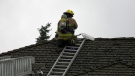 A CFD member on a home on Douglas Woods Terrace S.E. on August 6 after lightning started a fire on the roof