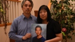 Samson and Chelly Wong hold a photo of their son, Alfred. 