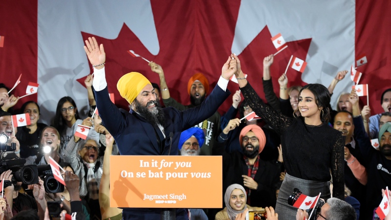 NDP leader Jagmeet Singh and his wife Gurkiran Kaur wave to supporters on stage at NDP election headquarters in Burnaby, B.C. on Monday, Oct. 21, 2019. THE CANADIAN PRESS/Nathan Denette