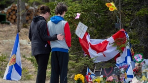 Visitors to a roadside memorial pays their respects in Portapique, N.S. on Friday, April 24, 2020. (Courtesy: THE CANADIAN PRESS/Andrew Vaughan)