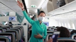 A flight attendant gives instructions to passengers on a plane in Ho Chi Minh City, Vietnam on Monday, March 16, 2020. (AP Photo/Hau Dinh)