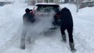 Saskatoon residents push a car through the snow on Nov. 11, 2020. (Laura Woodward/CTV Saskatoon)