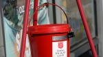 The iconic Salvation Army donations collections bucket swings outside a Corner Market grocery store in Jackson, Miss., Wednesday, Nov. 25, 2020, as a bell ringer, unseen, wishes customers a "Happy Thanksgiving," while non-vocally soliciting for donations. (AP Photo/Rogelio V. Solis)