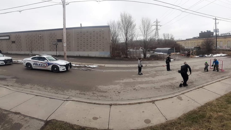 London Police officers play a game of road hockey with some local youths. (Tiffany Leroux / Facebook)