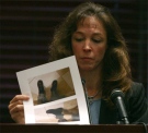 Former astronaut Lisa Nowak looks at photos while testifying during a hearing at the Orange County courthouse in Orlando, Fla., Aug. 24, 2007.(AP / Red Huber)