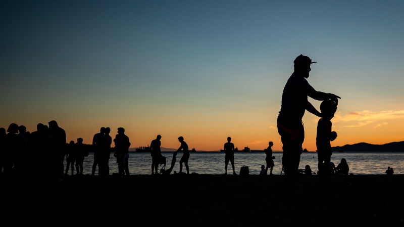 People are silhouetted at English Bay Beach at sunset, in Vancouver, B.C., on Monday, June 21, 2021. THE CANADIAN PRESS/Darryl Dyck 