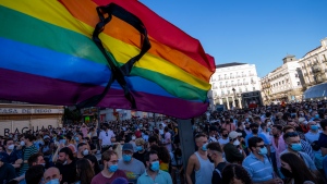 The rainbow flag with a black ribbon flutters during a protest against the killing of Samuel Luiz in the Puerta del Sol in central Madrid, Spain, Monday, July 5, 2021.  (AP Photo/Bernat Armangue) 
