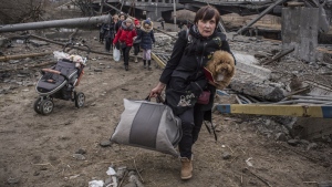 People cross an improvised path under a destroyed bridge while fleeing the town of Irpin, Ukraine, on March 6, 2022. (AP Photo/Oleksandr Ratushniak)