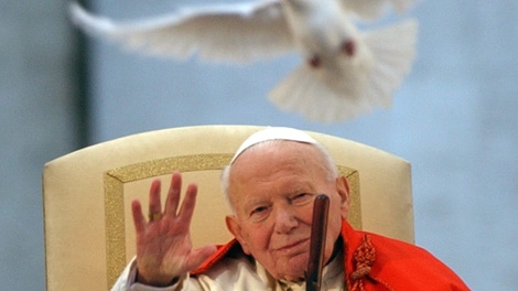 This April 10, 2003 file photo shows Pope John Paul II as a white dove is released in honor of his repeated calls for peace by Roman youths, in St. Peter's Square at the Vatican. (AP Photo/Massimo Sambucetti, file)