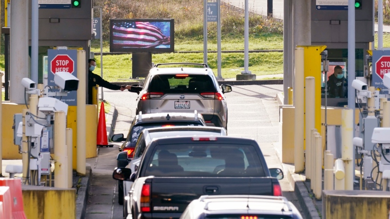 FILE - Cars line up to enter the U.S. from Canada at the Peace Arch border crossing Monday, Nov. 8, 2021, in Blaine, Wash. (AP Photo/Elaine Thompson)
