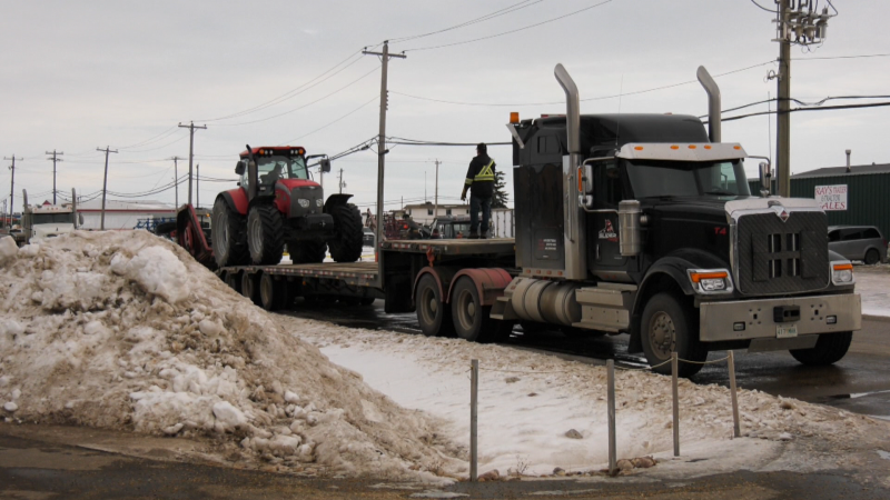 Police conducted 17 search warrants at addresses in Camrose and the surrounding area on Nov. 21, 2022, as part of a "property crime" investigation. In this photo, a tractor is driven onto a trailer. 