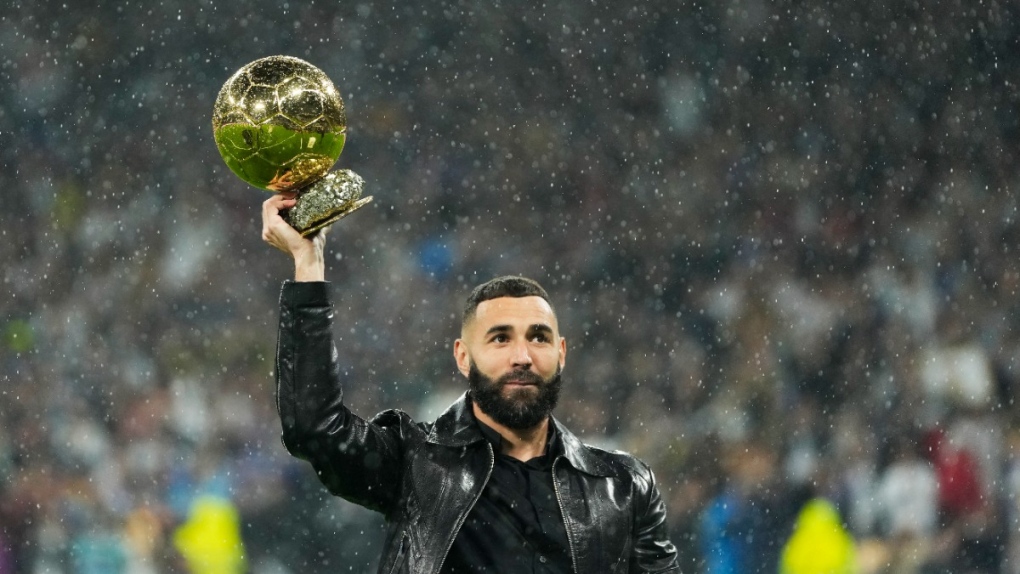 Karim Benzema holds the 2022 Ballon d'Or trophy