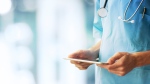 A nurse holds a tablet in this stock image. (Shutterstock) 