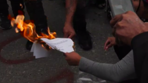 A copy of the injunction was burned, bringing a cheer from the growing crowd. (Source: Danton Unger, CTV News)