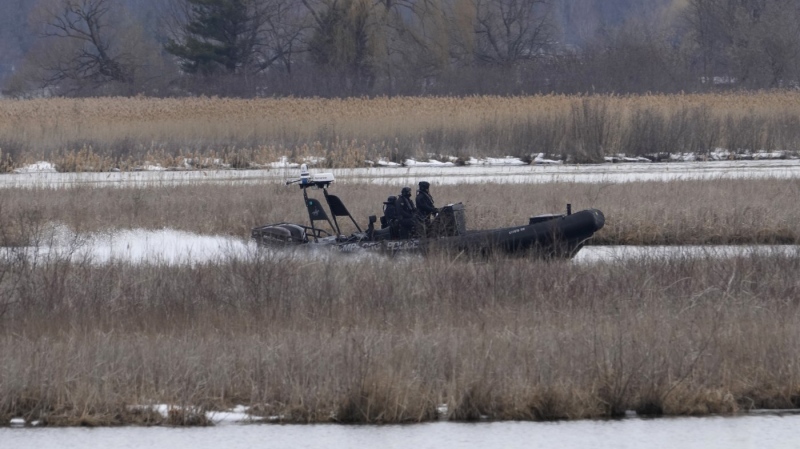 A police boat searches in the Mohawk Territory in Akwesasne, Que., Friday, March 31, 2023. The Akwesasne Mohawk Police Service says it has recovered the body of a man who is connected to the investigation into the deaths of eight migrants. THE CANADIAN PRESS/Ryan Remiorz