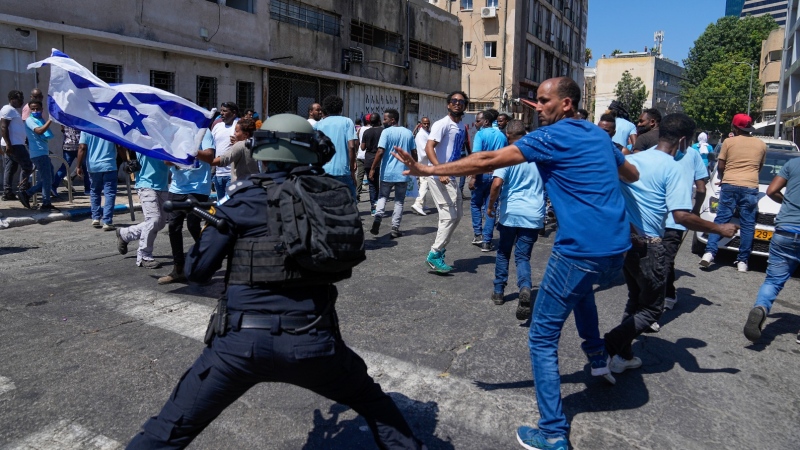 Eritrean protesters clash with Israeli riot police in Tel Aviv, Israel, Saturday, Sept. 2, 2023. Hundreds of Eritrean asylum seekers smashed shop windows and police cars in Tel Aviv on Saturday and clashed with police during a protest against an event organized by the Eritrea Embassy. The Israeli police said 27 officers were injured in the clashes, and at least three protesters were shot when police opened fire with live rounds when they felt "real danger to their lives." (AP Photo/Ohad Zwigenberg)