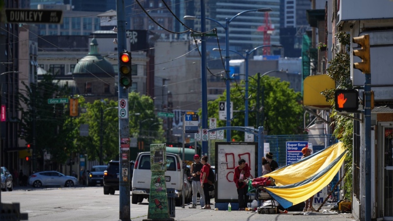 A tarp is seen draped between a building and a shopping cart to provide shade from the sun in the Downtown Eastside of Vancouver, B.C., Saturday, May 13, 2023. THE CANADIAN PRESS/Darryl Dyck